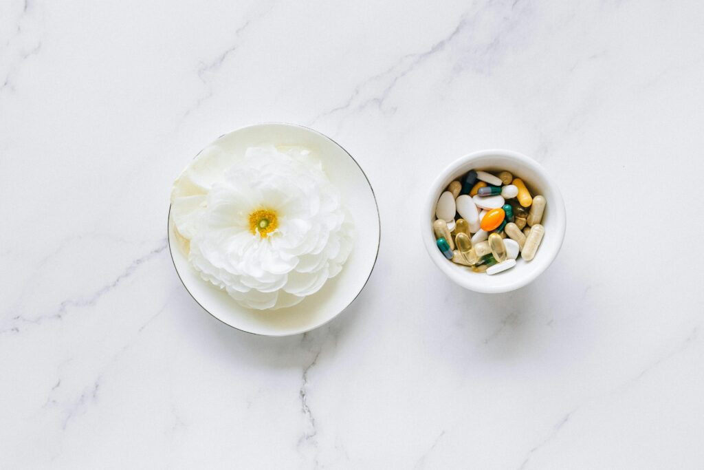 Picture of a cup holding supplements Ceramic cup filled with assorted daily supplements and vitamins, including capsules and tablets for focus and memory