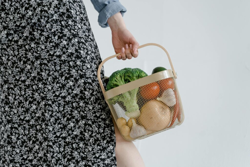 South african woman holding a basket of vegetables South African woman holding a basket of fresh vegetables, promoting a balanced diet alongside traditional pap meals.